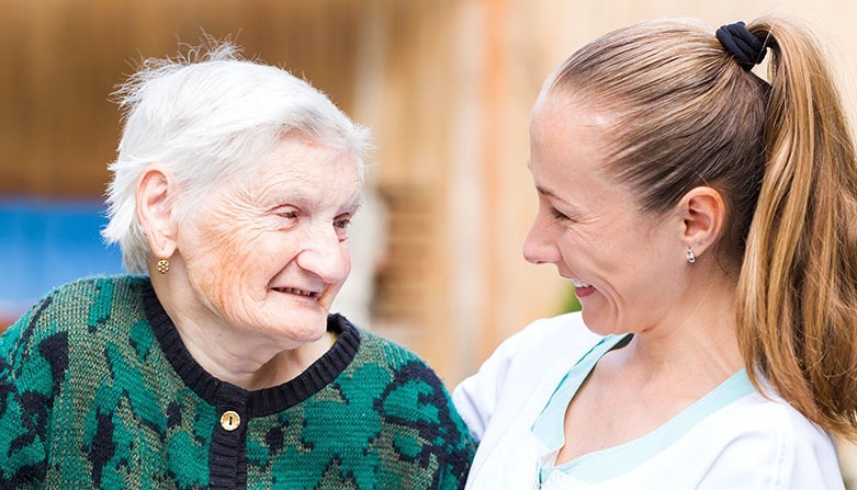 A woman smiling at an elderly lady