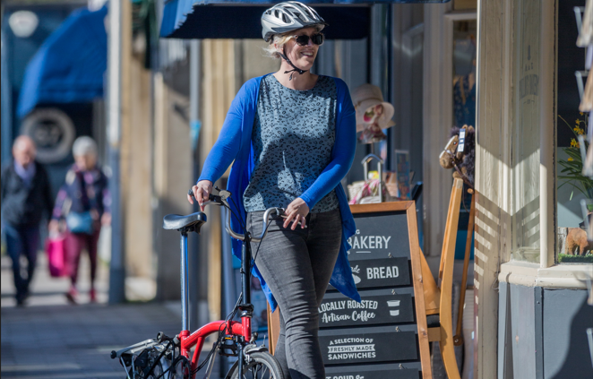 woman walking with bike near the shops