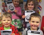 children holding pieces of card with poems written on them