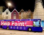 purple bus with 'help point' written on the windows against the night sky