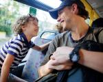 Man and his son on a bus - they are grinning at each other