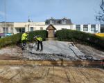 Two contractors swing hammers to remove the concrete covering on the floral clock at Weston-super-Mare