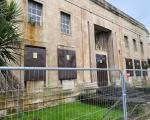 Former magistrates court with fencing outside