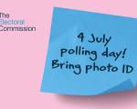 A sticky note with writing on it that reads "4 July polling day! Bring photo ID."