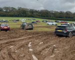 cars parked erratically in extremely muddy field 