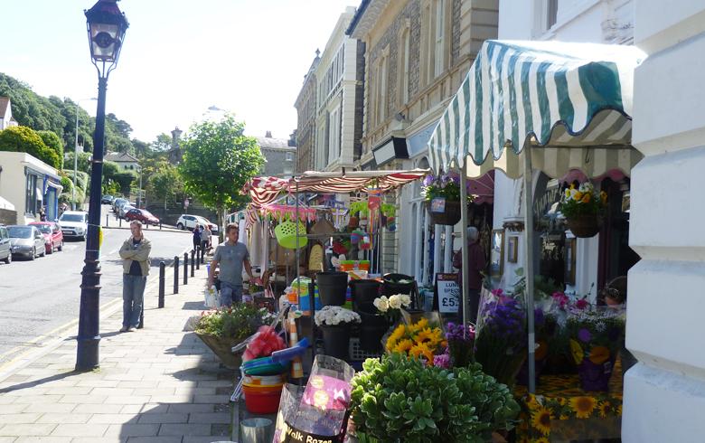 Flowers and a striped awning line a historic street in Clevedon for the filming of ITV's Broadchurch