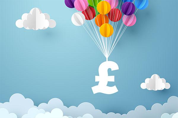 a white pound sign being held up by a string of colourful balloons