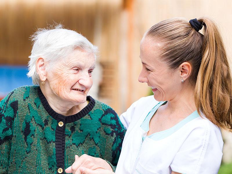 elderly lady smiling with her carer