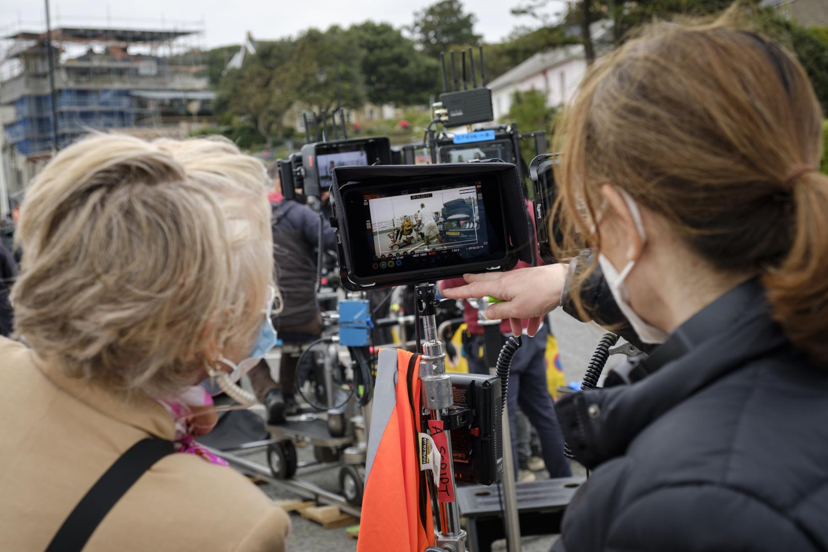 A photo of two people looking at an image through a camera when filming a production on the seafront in Clevedon.