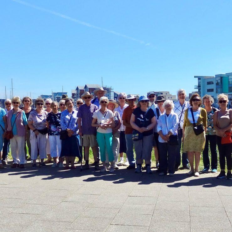 Group of people stood in front of Portishead Marina, smiling at camera