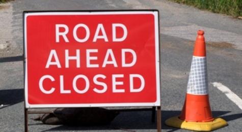 Picture of a sign saying road ahead closed