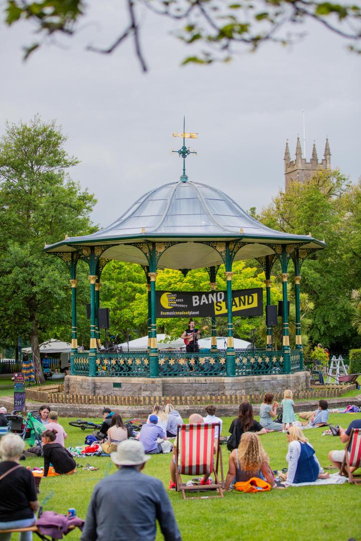 A photo of Grove Park in Weston-super-Mare taken when an event was taking place. People are in the park enjoying entertainment in the bandstand
