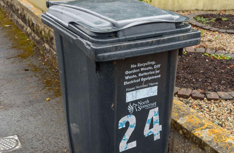 A black waste bin